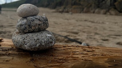 Piedras apiladas haiendo figura sobre un tronco