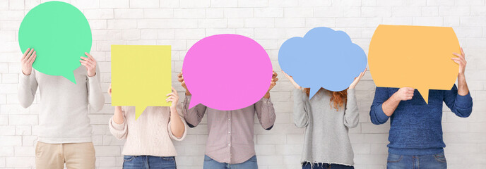 Friends holding speech bubbles with copy space over white wall, crop