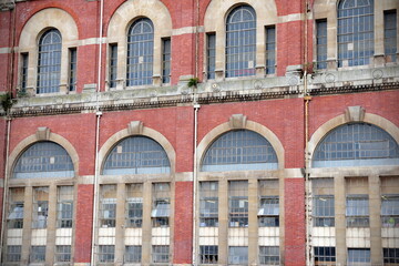 Exterior of an old red brick building with large windows