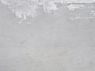 Background of old cement wall hasn't been finished with painted. Damaged cement wall with uneven paint and not full cover. Rough surface texture of cement wall in the process of repair and repainting.