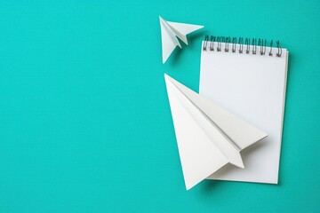 Composition with stationery supplies and paper plane on turquoise background
