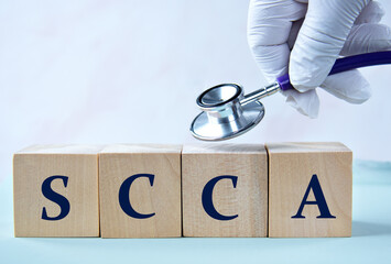 Cubes with the abbreviation SCCA in the hand of a doctor.
