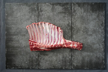 Raw rack of lamb on dark background
