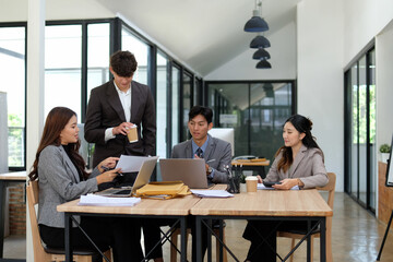 Smiling business people talking in the office, discussing business work together.