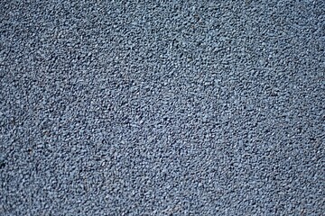 Blue sports field rubber coating close up. Playground paving background texture.