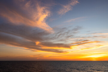 A dramatic set of clouds, at sunset, drifting over the tropical waters of the Caribbean Sea are lit...