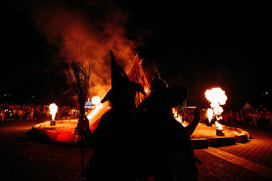Walpurgisnacht, Maifeuer oder Hexenfeuer. Eine Hexe posiert vor einem gro&szlig;en Lagerfeuer / Scheiterhaufen. 