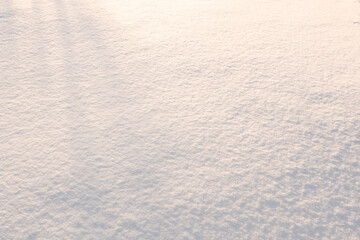 Natural snow texture. The surface of an icy snow crust. Snowy ground. Winter background with snow patterns. Closeup top view.
