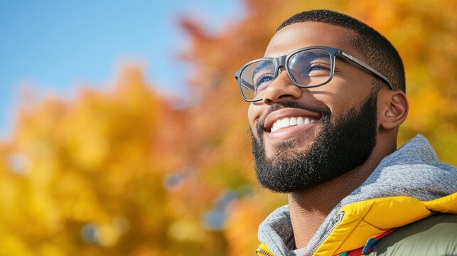 A man with glasses and a beard is smiling and looking up at the sky. Concept of happiness and contentment