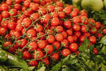 Fresh bio red ripe cherry tomatoes with parsley in a street food market, close up