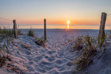 Sunset over the Baltic Sea at Darß Peninsula showcasing tranquil shoreline and sandy pathway