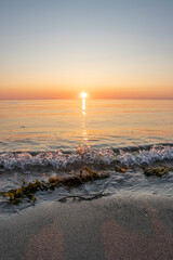 Sunset over the tranquil Baltic Sea on Darß Peninsula in Germany reflecting warm hues of orange and pink