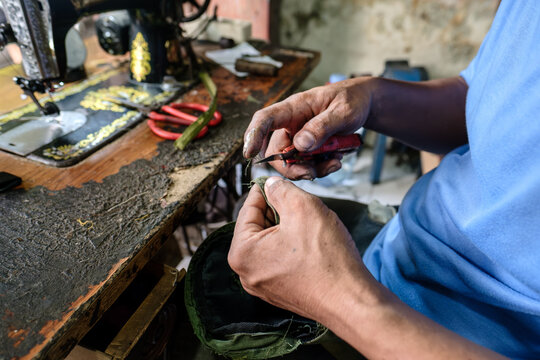 Tailor cutting fabric with small knife at sewing workshop - Powered by Adobe