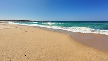 Fototapeta premium A Beautiful and Peaceful Beach Landscape Featuring Clear Blue Waters and a Sandy Shoreline