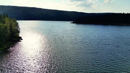 A Serene Lake That is Surrounded by Beautiful Lush Hills and Glimmering Sunlit Waters