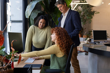 Business team collaborating on computer in modern office