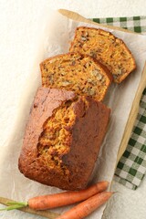 Homemade carrot cake with nuts and vegetables on white textured table, top view