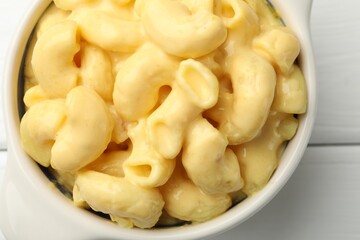 Delicious macaroni and cheese on white wooden table, top view