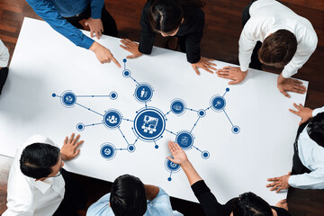 A diverse business team convenes around a table, actively collaborating on strategic management...