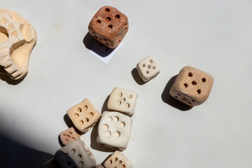 Handcrafted clay Roman dice are displayed for sale alongside a clay skull at  a table