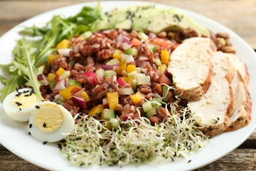 Tasty salad with brown rice on wooden table, closeup