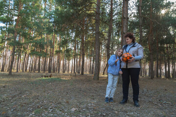 Obraz premium Grandmother and granddaughter playing with a ball in the forest in sunny day.