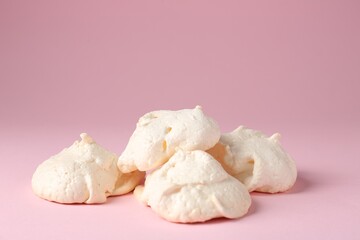 Delicious homemade meringue cookies on pink background