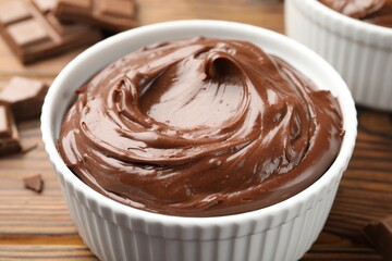 Tasty chocolate pudding in bowls on wooden table, closeup