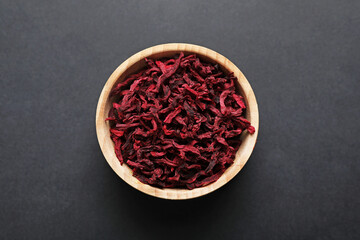 Dried beetroots in bowl on dark table, top view