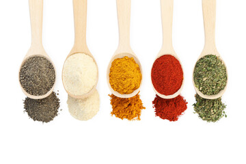 Different aromatic spices in wooden spoons isolated on white, above view