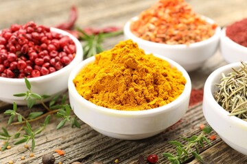 Different aromatic spices on wooden table, closeup