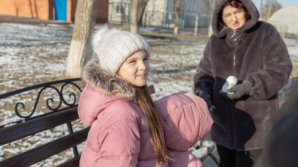 Grandparents with granddaughters playing in the park on a sunny winter day
