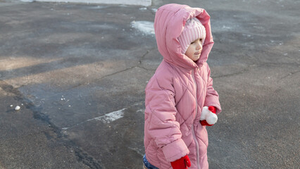 Little girl walking on a sunny winter day