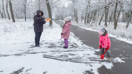 Grandmother playing with granddaughters at park in winter