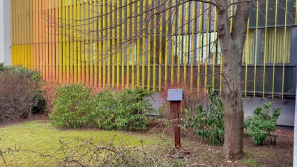 A Modern Architectural Design Featuring a Colorful Facade and Lush Greenery Elements Surrounding It