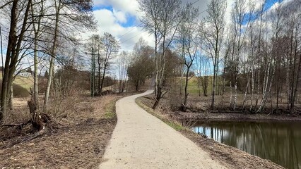 Experience the serene pathway beside the water during the beautiful early spring season