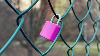 A Vibrant Pink Padlock Situated on a Bright Green Fence Creating a Unique Visual Impact