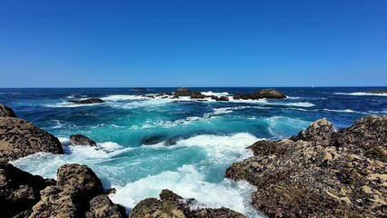 Experience the Serene Nature of Coastal Waves Gently Crashing Against Rocky Shores