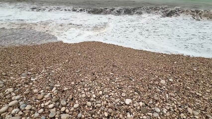 A Serene Beach Adorned with Smooth Pebbles and Gentle Waves Lapping at the Shoreline