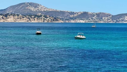 Obraz premium This is a stunningly serene seascape featuring picturesque boats sailing under bright blue skies