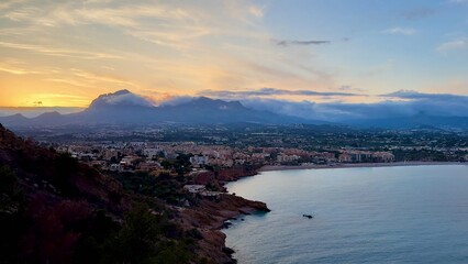 Breathtaking and Stunning Sunset Over Coastal City with Beautiful Mountains in View