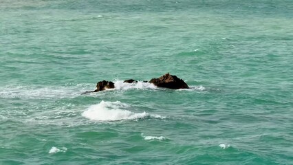 Fototapeta premium A Serene Coastal Rock Formation Surrounded by Crystal Clear Waters Offers a Picturesque View