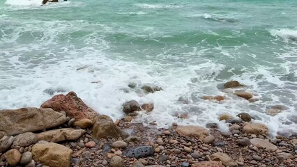 Waves create a beautiful spectacle as they crash upon the rugged rocky shoreline of the coast
