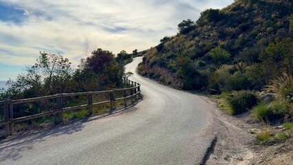 A beautiful, scenic winding road meandering through nature, adorned with charming fencing