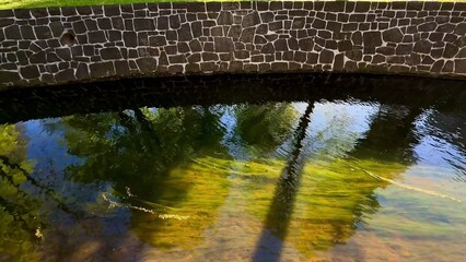 Tranquil Reflections by a Peaceful StoneWalled Pond Embodying Natures Calm Beauty and Serenity