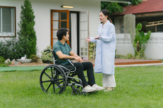 Doctor Consulting with Patient in Wheelchair Outdoors