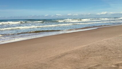 A Serene Beach Landscape Featuring Gentle Waves and a Beautiful, Clear Blue Sky Above