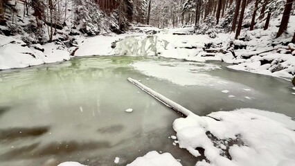 Forest winter river and waterfall