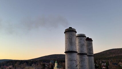 Smokestacks silhouetted at a stunning sunset sky create a breathtaking atmosphere