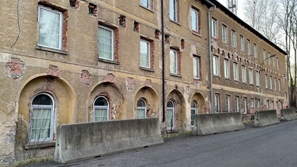 Obraz premium Abandoned Industrial Building in a Wealthy Urban Area with Diverse Architectural Features